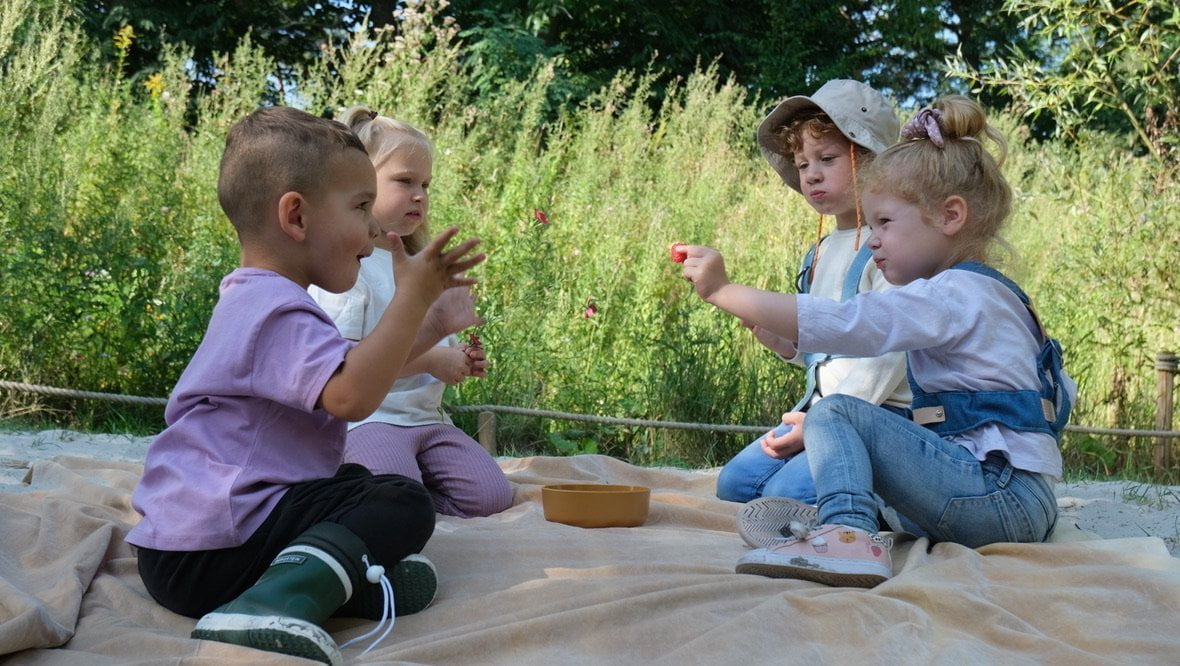 kinderen picknicken, eten aardbeien en hebben explorer belt om, moddermonstertje.nl webshop kinderen avonturen