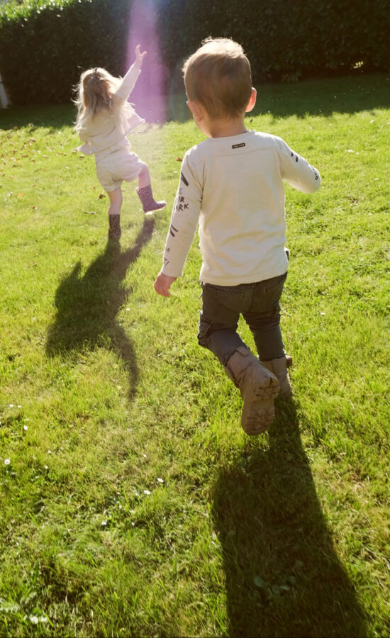 Kinderen spelen in de zon in het gras, moddermonsterje.nl webshop